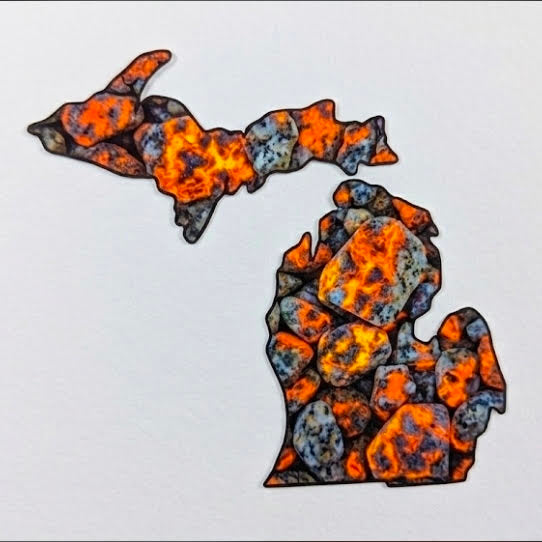 A map-shaped decorative piece of the state of Michigan filled with a textured orange, black, and gray yooperlite pattern.